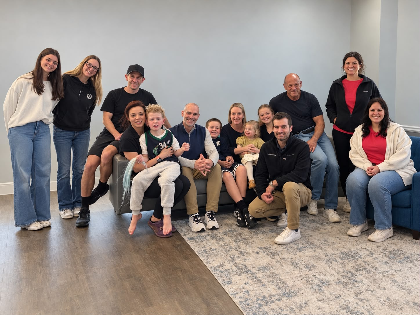 The clinic team and families gathered around a sofa.